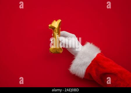 12 Tage von Weihnachten. Santa Hände halten 1. tag Ballon auf rotem Hintergrund Stockfoto