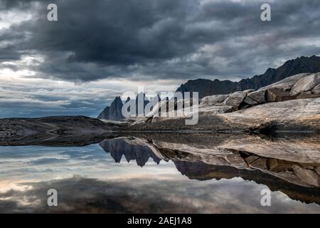 Küste bei Tungeneset, Blick über Zähne spitzen Rock Formation des berühmten Teufel der Bergkette Okshornan, Insel Senja, Troms, Norwegen im Norden. Stockfoto