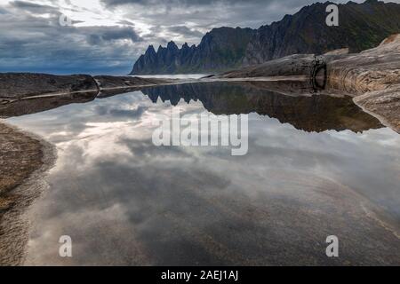 Küste bei Tungeneset, Blick über Zähne spitzen Rock Formation des berühmten Teufel der Bergkette Okshornan, Insel Senja, Troms, Norwegen im Norden. Stockfoto