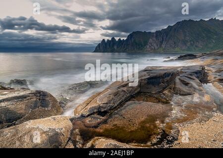 Küste bei Tungeneset, Blick über Zähne spitzen Rock Formation des berühmten Teufel der Bergkette Okshornan, Insel Senja, Troms, Norwegen im Norden. Stockfoto