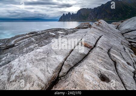 Küste bei Tungeneset, Blick über Zähne spitzen Rock Formation des berühmten Teufel der Bergkette Okshornan, Insel Senja, Troms, Norwegen im Norden. Stockfoto