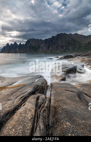 Küste bei Tungeneset, Blick über Zähne spitzen Rock Formation des berühmten Teufel der Bergkette Okshornan, Insel Senja, Troms, Norwegen im Norden. Stockfoto