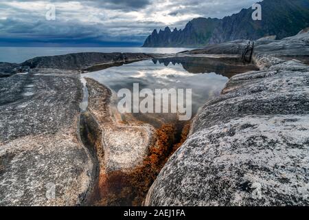 Küste bei Tungeneset, Blick über Zähne spitzen Rock Formation des berühmten Teufel der Bergkette Okshornan, Insel Senja, Troms, Norwegen im Norden. Stockfoto