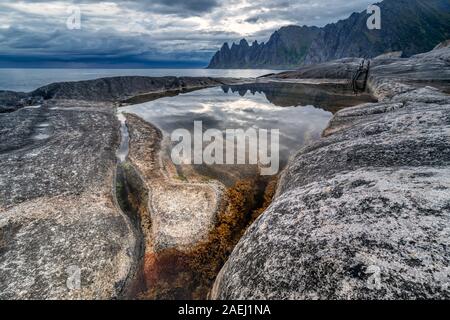 Küste bei Tungeneset, Blick über Zähne spitzen Rock Formation des berühmten Teufel der Bergkette Okshornan, Insel Senja, Troms, Norwegen im Norden. Stockfoto