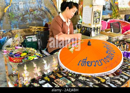 Thai Frau Malerei ein Papier Regenschirm in Bo Sang Papier Regenschirm Dorf, Nordthailand Stockfoto