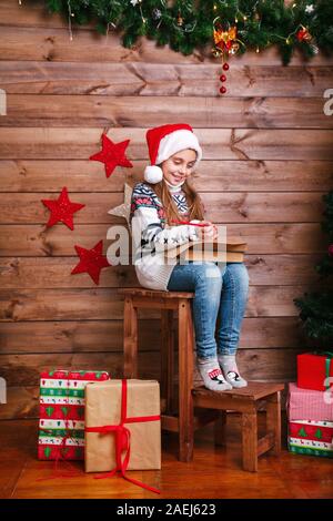 Happy little Girl schreibt Brief an Santa Claus im Weihnachtsbaum Stockfoto