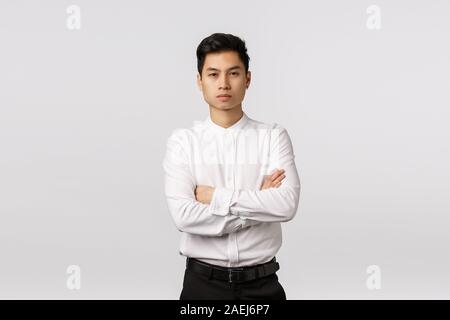 Corporate promo, Rekrutierung und Geschäftsidee. Attraktive selbstbewusste asiatische männliche Unternehmer, die Arme über der Brust, suchen Kamera fokussiert und Stockfoto