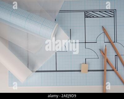 Architekturzeichnungen für das Layout des Wohnungsdesigns, Millimeterpapier, Zeichenpapier in einer Rolle und Bleistifte Stockfoto