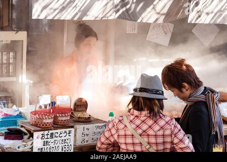 Beppu, Japan - 29 Dezember, 2009: Der junge Mann und Frau kaufen von einem Fast Food Street Verkäufer gekochte Eier, beliebten Fast food in Beppu. Stockfoto