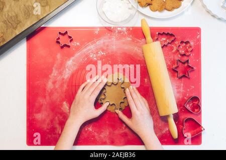 Weihnachtsbäckerei. Frau, die Lebkuchen, schneiden Cookies von Lebkuchen Teig, Ansicht von oben. Festliche Essen, Kochen, kulinarisch, Chr Stockfoto