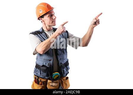 Die Builder zeigt nach rechts. Bietet mit dem Index Finger. In Arbeitskleidung und harten Hut. Stockfoto