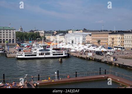 Anzeigen von Menschen Sonnenbaden an Allas Meer Pool in der Nähe von South Harbour mit Suomenlinna Fähre und den alten Markt Vanha Kauppahalli im Hintergrund erhöhten, Helsink Stockfoto