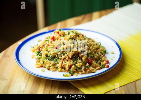 Hausgemachte veganes Essen (vegane) von Bulgur Salat Müsli mit frischem Gemüse, Spinat, Avocado, Gewürzen und Olivenöl. Gesund essen Bio eco-Konzept. Stockfoto