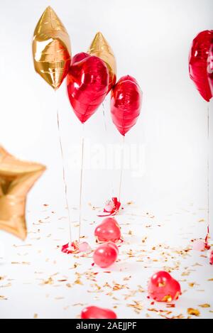 Gel Kugeln wie rote Herzen, gelbe Sterne der festlichen knetti, auf einem weißen Hintergrund. Valentinstag. Stockfoto