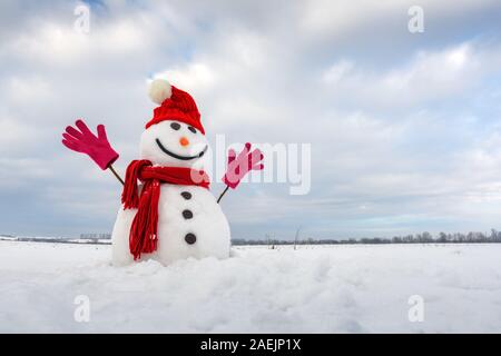 Lustige Schneemann in stilvollen Red Hat, Red scalf und rote Handschuhe auf schneebedeckten Feld Stockfoto