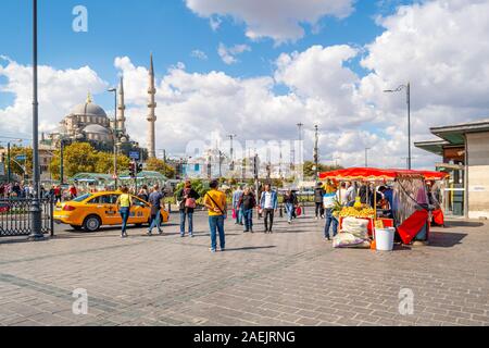 Straßenszene in Istanbul Türkei mit lokalen Türken, Maiskolben Anbieter, Taxi und die Süleymaniye Moschee in Aussicht. In der Nähe der Galata-Brücke. Stockfoto