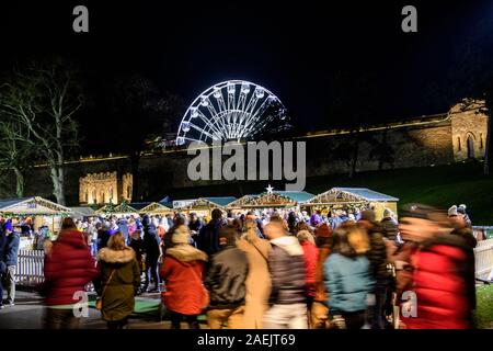 Die Lincoln Weihnachten Marktstände im Inneren des Lincoln Castle in der Nacht, mit dem Riesenrad im Hintergrund. Stockfoto