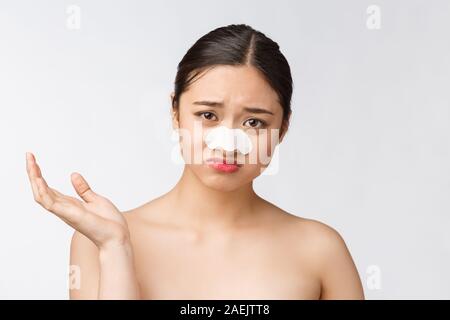 Kosmetologie. Portrait von schönen weiblichen asiatischen Modell mit Maske auf der Nase. Nahaufnahme des gesunden jungen Frau mit Reine weiche Haut und frisches natürliches Make Up. Stockfoto