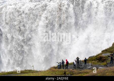 Touristen, die auf der Suche am Wasserfall Dettifoss, Island Stockfoto