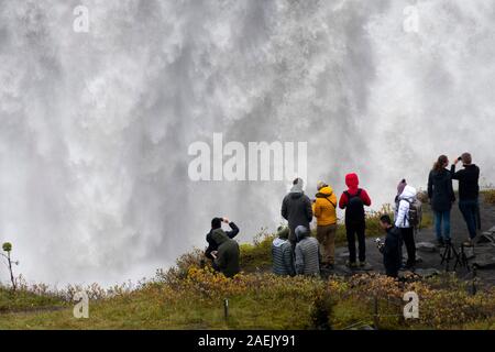 Touristen, die auf der Suche am Wasserfall Dettifoss, Island Stockfoto