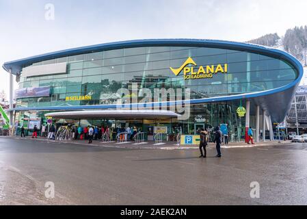 Schladming, Steiermark/Österreich - Skifahrer und Touristen vor der Talstation Planai Schladming. Ski Station mit Geschäften, Skidepot, Informa Stockfoto