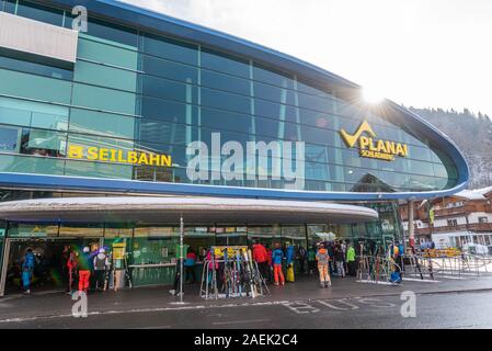 Schladming, Steiermark/Österreich - Skifahrer und Touristen vor der Talstation Planai Schladming. Ski Station mit Geschäften, Skidepot, Informa Stockfoto