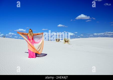 Traum - wie Szene. Elegante Frau, trug einen Fancy Dress und stehen wie ein Märchen unter den Yuccas bei Sonnenuntergang in der Wüste von White Sands National Monu Stockfoto