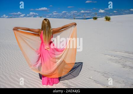 Traum - wie Szene. Elegante Frau, trug einen Fancy Dress und stehen wie ein Märchen unter den Yuccas bei Sonnenuntergang in der Wüste von White Sands National Monu Stockfoto