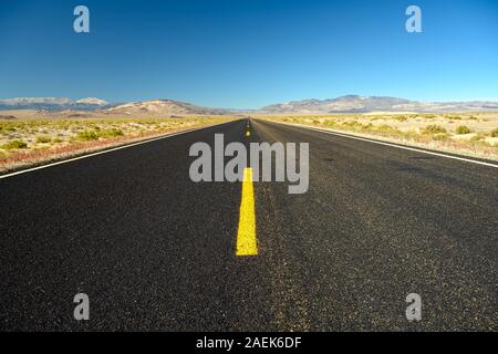 Leere Straße, geradeaus bis zum Horizont, führt zu nichts Stockfoto