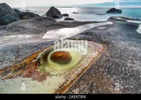 Der Drache Auge geformt Rock bei Uttakleiv Strand, Lofoten, der norwegischen Arktis. Lange Belichtung. Stockfoto