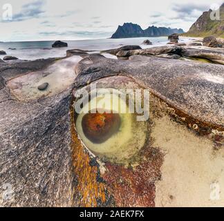 Der Drache Auge geformt Rock bei Uttakleiv Strand, Lofoten, der norwegischen Arktis. Lange Belichtung. Stockfoto