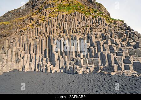 Dramatische Basaltsäulen, die auf entfernten Strand Reynisfjara in der Nähe von Vik, Island Stockfoto