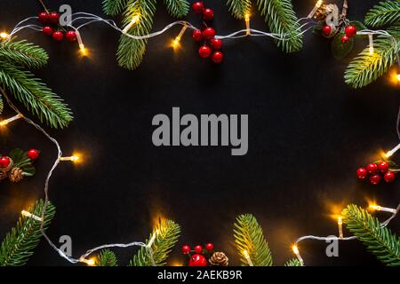 Urlaub Weihnachten Karte Hintergrund mit festlichen Dekoration Kugel, Sterne, Schneeflocken, Geschenkbox, Tannenzapfen auf schwarzem Hintergrund von Flach, Ansicht von oben. Stockfoto