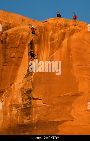 Ein BASE jumper Sprünge von der Spitze des 400-Fuß vertikale Teilfläche der Tombstone in der Kane Springs Canyon in der Nähe von Moab, Utah. Hinweis seinen Schatten auf die Klippe. Stockfoto