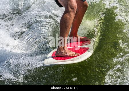 Eine Nahaufnahme eines wakesurfer Füße auf dem Board, wie er reitet der Surf Wave mit einem Boot wake am Lake Powell, Glen Canyon National Recreation Area, Uta Stockfoto