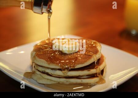 Stapel Pfannkuchen mit Sirup gießen über Sie Stockfoto