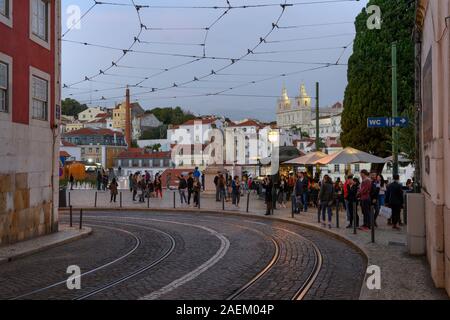 Menschen auf der Straße mit Kloster São Vicente de Fora im Hintergrund, Sao Miguel, Lissabon, Portugal Stockfoto