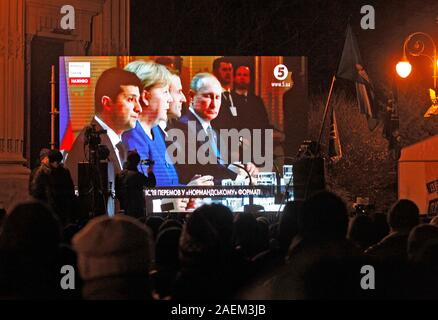 Kiew, Ukraine. 10 Dez, 2019. Die Ukrainer sehen eine gemeinsame Pressekonferenz im Anschluss an die Normandie vier Leaders Summit, Volodymyr Zelensky, Wladimir Putin, Merkel und Emmanuel Längestrich, außerhalb des Präsidialbüros in Kiew. Ein Normandie Format Gipfel mit der Teilnahme von Verantwortlichen der Ukraine, Russland, Frankreich und Deutschland hinsichtlich der Konflikte in der östlichen Ukraine wurde in Paris statt. Credit: SOPA Images Limited/Alamy leben Nachrichten Stockfoto