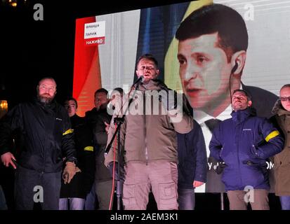 Kiew, Ukraine. 10 Dez, 2019. Die Ukrainer sehen sie sich einer gemeinsamen Pressekonferenz während der Normandie vier Leaders Summit, mit dem ukrainischen Präsidenten Wladimir Zelensky auf einem Bildschirm außerhalb des Präsidialbüros in Kiew. Ein Normandie Format Gipfel mit der Teilnahme von Verantwortlichen der Ukraine, Russland, Frankreich und Deutschland hinsichtlich der Konflikte in der östlichen Ukraine gesehen wurde in Paris statt. Credit: SOPA Images Limited/Alamy leben Nachrichten Stockfoto
