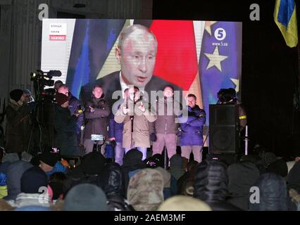 Kiew, Ukraine. 10 Dez, 2019. Die Ukrainer sehen sie sich einer gemeinsamen Pressekonferenz während der Normandie vier Leaders Summit, mit dem russischen Präsidenten Wladimir Putin, auf einem Bildschirm außerhalb des Präsidialbüros in Kiew. Ein Normandie Format Gipfel mit der Teilnahme von Verantwortlichen der Ukraine, Russland, Frankreich und Deutschland hinsichtlich der Konflikte in der östlichen Ukraine gesehen wurde in Paris statt. Credit: SOPA Images Limited/Alamy leben Nachrichten Stockfoto