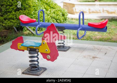 Auf Kind Spielplatz im Park Wippe. childs Ausritt mit dem Pferd in den Spielplatz. Schwingen auf einer metallspirale. Feder Pferd auf dem Spielplatz. Stockfoto