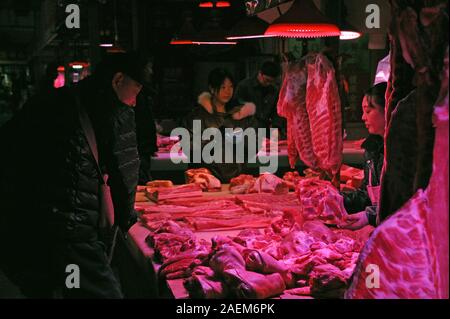 Kunden kaufen Schweinefleisch um einen Stand auf einem lokalen Markt in Tianjin, China, 16. November 2019. Der Preis für Schweinefleisch weiter gehen als die Regierung o Stockfoto