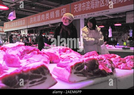 Kunden kaufen Schweinefleisch um einen Stand auf einem lokalen Markt in Tianjin, China, 16. November 2019. Der Preis für Schweinefleisch weiter gehen als die Regierung o Stockfoto