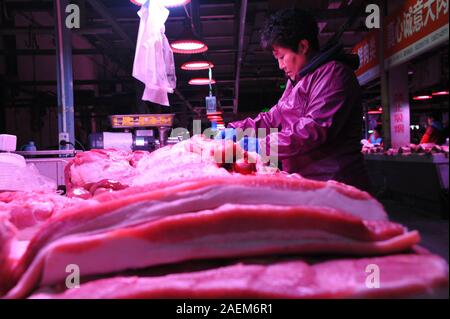Kunden kaufen Schweinefleisch um einen Stand auf einem lokalen Markt in Tianjin, China, 16. November 2019. Der Preis für Schweinefleisch weiter gehen als die Regierung o Stockfoto