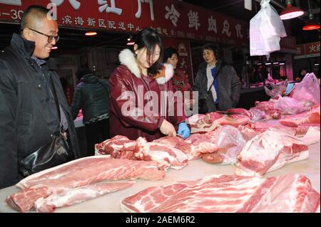 Kunden kaufen Schweinefleisch um einen Stand auf einem lokalen Markt in Tianjin, China, 16. November 2019. Der Preis für Schweinefleisch weiter gehen als die Regierung o Stockfoto