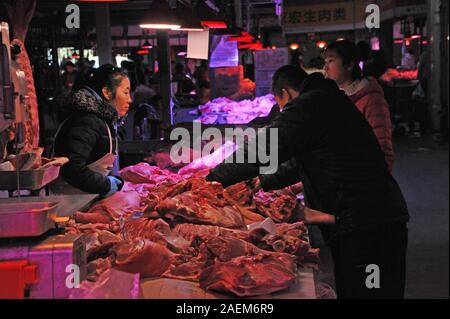 Kunden kaufen Schweinefleisch um einen Stand auf einem lokalen Markt in Tianjin, China, 16. November 2019. Der Preis für Schweinefleisch weiter gehen als die Regierung o Stockfoto