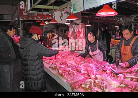 Kunden kaufen Schweinefleisch um einen Stand auf einem lokalen Markt in Tianjin, China, 16. November 2019. Der Preis für Schweinefleisch weiter gehen als die Regierung o Stockfoto
