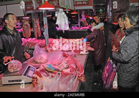 Kunden kaufen Schweinefleisch um einen Stand auf einem lokalen Markt in Tianjin, China, 16. November 2019. Der Preis für Schweinefleisch weiter gehen als die Regierung o Stockfoto
