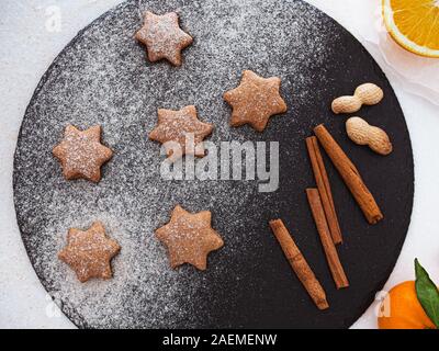 Weihnachtsfeiertag sternförmigen Lebkuchen cookies für die Dekoration mit Zucker Pulver, dunkel, Hintergrund, oben Stockfoto