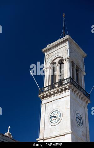 Kirchturm mit Uhr in Hydra auf Sunne Tag mit klaren klassischen blauen Himmel. Vertikale Stockfoto